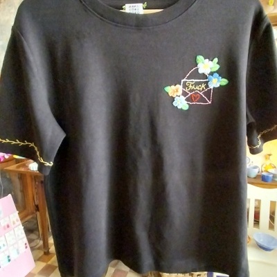T-shirt preta com bordado colorido de envelope, flores e texto Fuck no peito