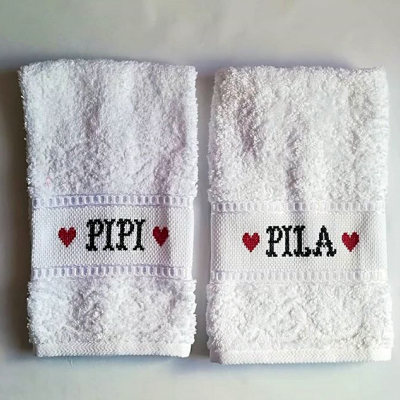 Duas toalhas brancas com nomes bordados PIPI e PILA com corações vermelhos