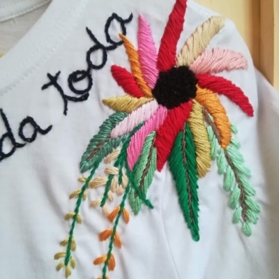 Camisola branca com bordado colorido de flor no ombro com texto bordado 'da toda'