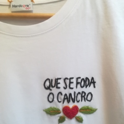 Camiseta branca com bordado colorido e texto em preto