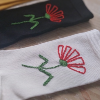 Três pares de meias com bordado de flor em cores branco, preto e amarelo