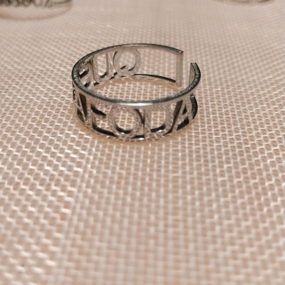 Anéis prateados em metal com design recortado, um anel com texto Vai Ficar Tudo Bem