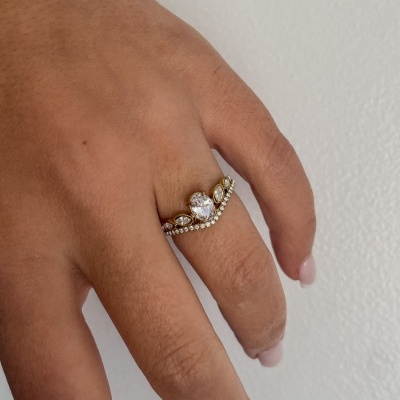Anel dourado com pedras brilhantes em dedo de mão