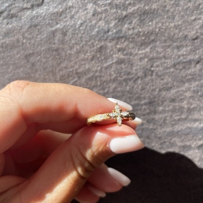 Anel dourado com pedras transparentes em forma de flor