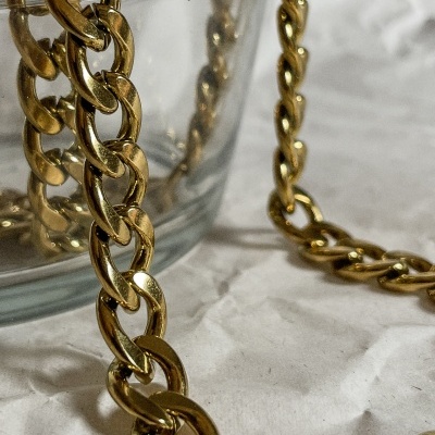 Corrente dourada grossa em taça de vidro