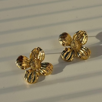 Brincos dourados em forma de flor com quatro pétalas e centro texturizado