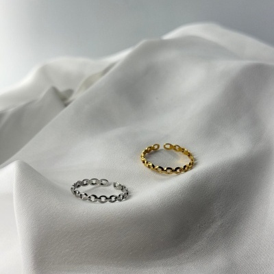 Dois anéis de elos, um prateado e outro dourado, sobre tecido branco