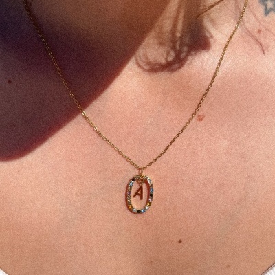 Colar dourado com pendente oval colorido e letra A