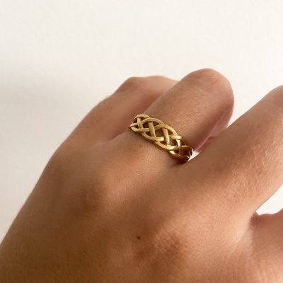 Anel dourado entrelaçado no dedo