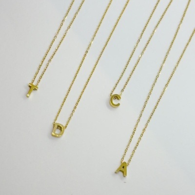 Quatro colares dourados com letras T, D, C e A