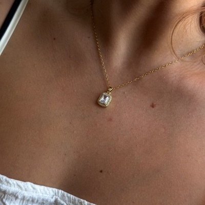 Colar dourado com pendente quadrado e pedra transparente