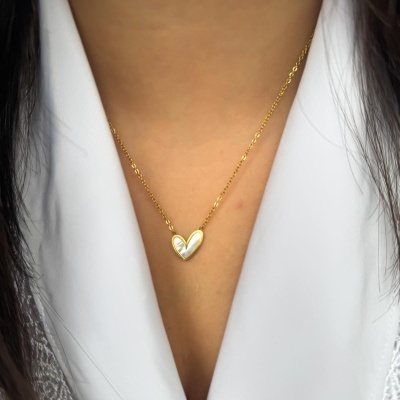 Colar dourado com coração de madrepérola usado com blusa branca