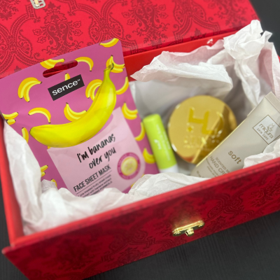 Caixa vermelha com produtos de beleza diversos e embalagem com design de bananas.
