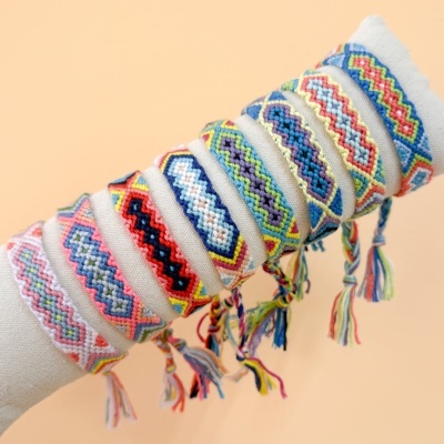 Pulseiras de tecido coloridas com padrões geométricos e franjas nas pontas