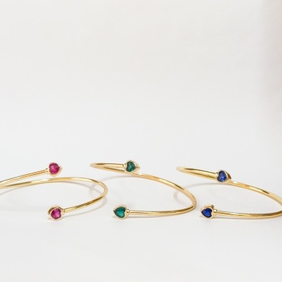 Pulseiras douradas com pedras em forma de coração rosa, verde e azul