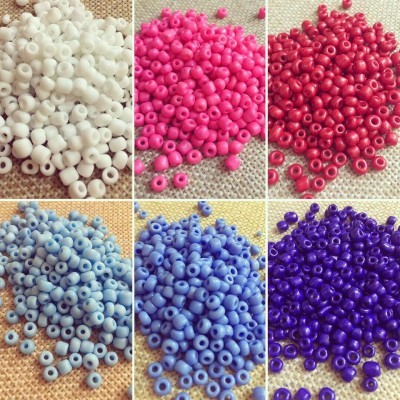 Seis grupos de contas coloridas redondas em tecido bege