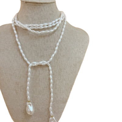 Colar de pérolas brancas onduladas exposto num manequim almofadado