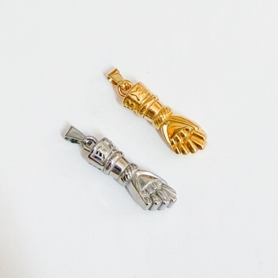 Dois pendentes metálicos em forma de punho fechado, dourado e prateado.