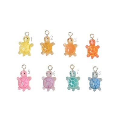 Oito pingentes coloridos de tartaruga com argolas metálicas para pendurar.