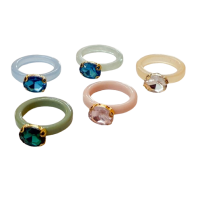 Conjunto de cinco anéis coloridos com pedras facetadas e molduras douradas