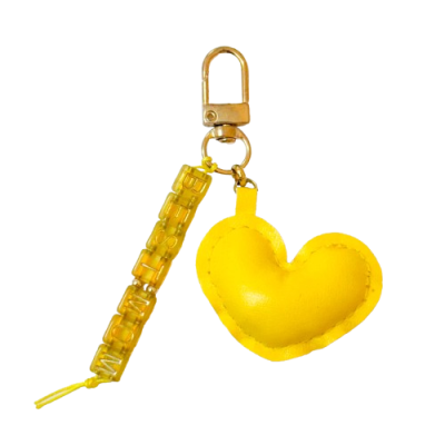 Chaveiro amarelo com coração e tira de letras em plástico translúcido