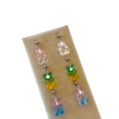 Brincos de ursinhos coloridos em acrílico num suporte bege