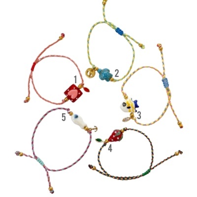 Conjunto de cinco pulseiras coloridas com diferentes pendentes de cerâmica ou vidro.