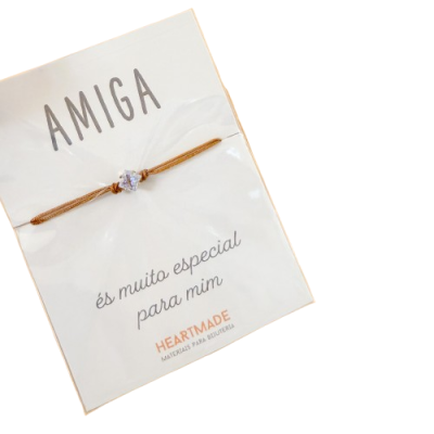 Pulseira com pedra transparente em cordão dourado num cartão branco com texto AMIGA és muito especial para mim