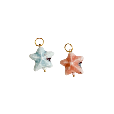 Dois pendentes em pedra em forma de estrela, um azul e outro rosa, com argola dourada
