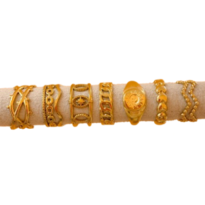 Sete pulseiras douradas com diferentes padrões sobre suporte bege