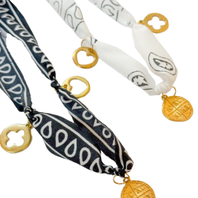 Dois colares de tecido estampado em preto e branco com medalhões dourados