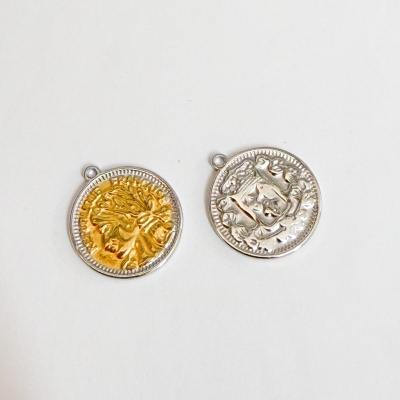 Dois pendentes redondos, um dourado e outro prateado, com relevos decorativos