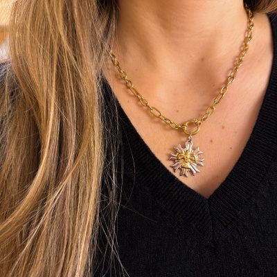 Colar dourado com pendente estrela prateada e figura dourada ao centro