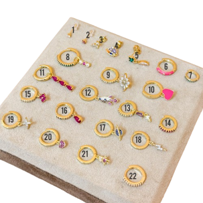 Mostruário beige com anéis dourados e pedras coloridas