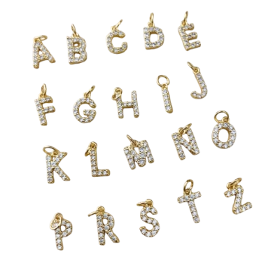 Pendentes de letras douradas com pedras brilhantes sobre fundo branco