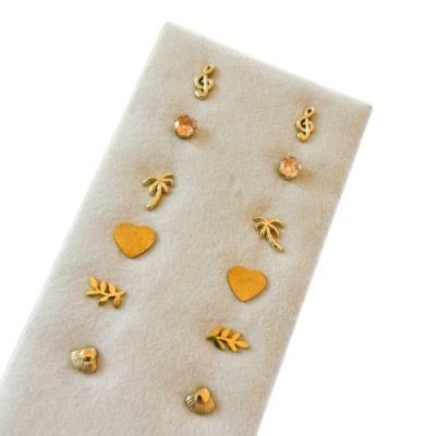 Conjunto de brincos dourados variados em base de tecido bege claro