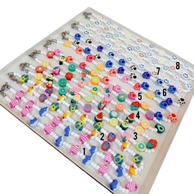 Conjunto de pulseiras coloridas com contas e desenhos variados em bandeja branca