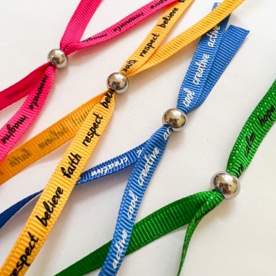 Pulseiras coloridas de fita com mensagens e fecho metálico