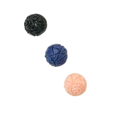 Três contas redondas esculpidas com padrão floral, nas cores preta, azul e cor-de-rosa.