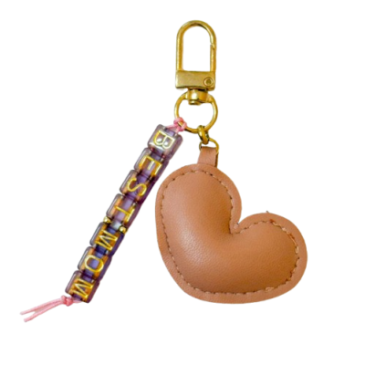 Chaveiro com coração castanho e tira transparente com letras douradas