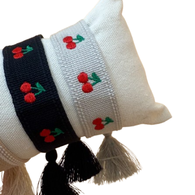 Pulseiras de tecido branco e preto com pádrão bordado de cerejas e borlas pendentes