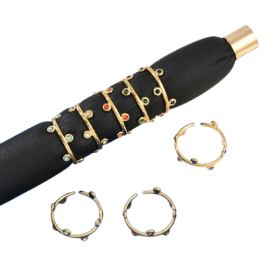 Anéis dourados com pedras coloridas em suporte de couro preto