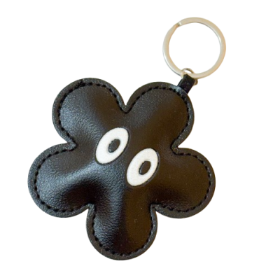 Chaveiro preto em forma de flor com olhos brancos e anilha metálica