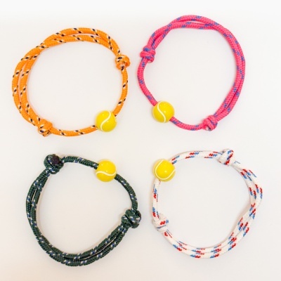 Quatro pulseiras coloridas de corda com bola amarela decorativa em fundo branco