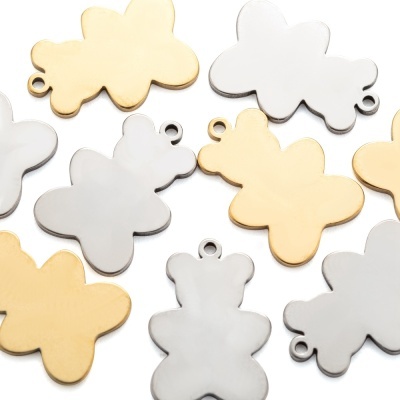 Pendentes de borboletas e ursos dourados e prateados em fundo branco