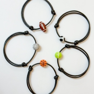 Pulseiras pretas com contas desportivas coloridas em fundo branco