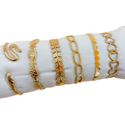 Seis pulseiras douradas com vários padrões exibidas em suporte branco