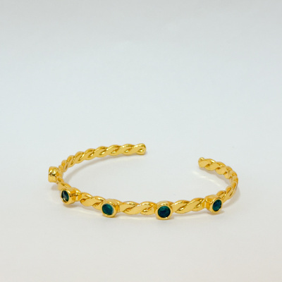 Pulseira dourada torcidacom pedras verdes.