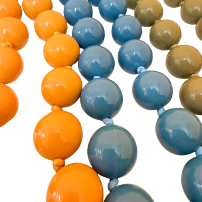 Colares de contas grandes coloridas laranja, azul e verde sobre fundo branco