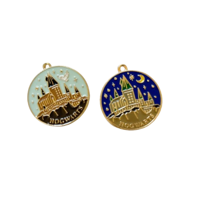 Dois pendentes redondos dourados com castelo de Hogwarts e texto 'HOGWARTS' em fundos azul claro e azul escuro